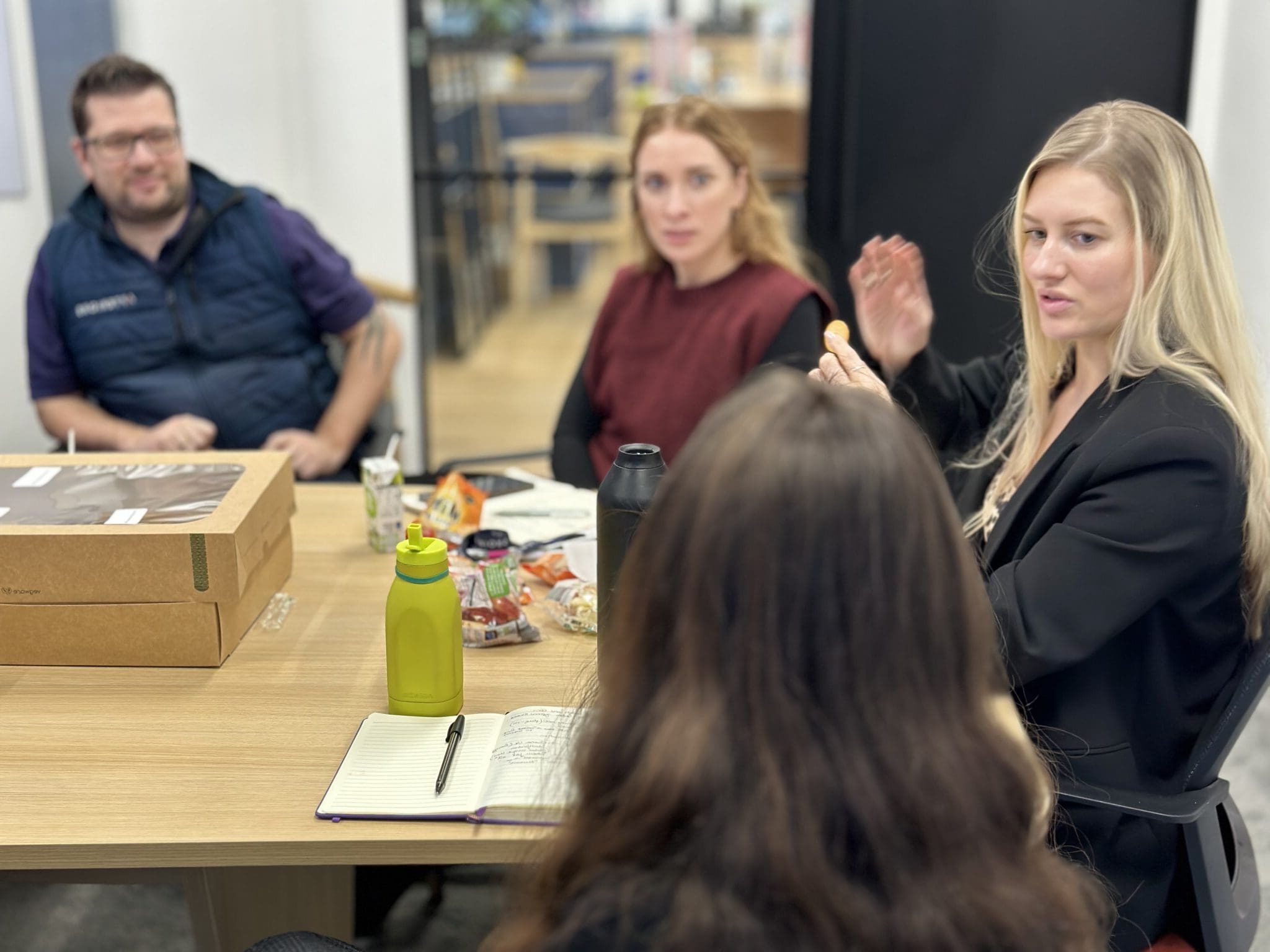 Catherine Mackay seated at a table with her team discussing Apteriors FF&E work